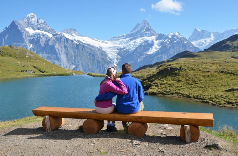 Par på bænk ved alperne i Schweiz